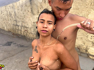 Young girl taking a hose bath in the backyard and dancing funk