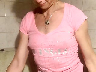 Soaking wet in bathroom in pink t-shirt, denim skirt and socks