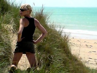 Slender blonde milf gives a wonderful handjob on the beach