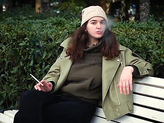 Young Brunette Is Taking an Unhurried Stroll with Allwhite 120mm Cigarette