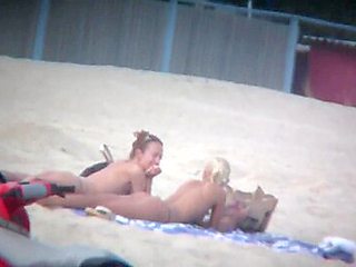 Beach spy captures two friends sunbathing topless