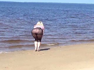 Jokey cougar with nylon caboose and breasts on beach