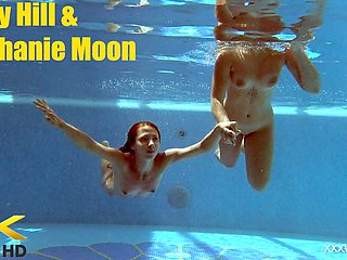In the indoor pool, two stunning girls swim