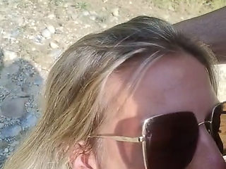 She sucks him at the water's edge