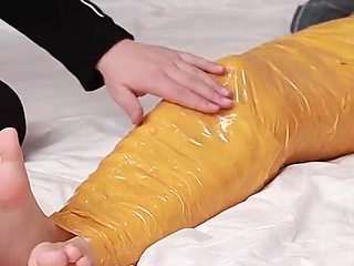 A Cute Barefoot Girlfriend Uses Tape to Bind Her Whole Body, Playing with Her Cute Bare Feet
