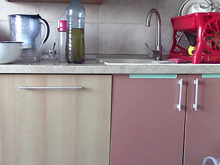 Sexy wife having fun in the kitchen with roses. Sexy naked wife preparing food in the kitchen.