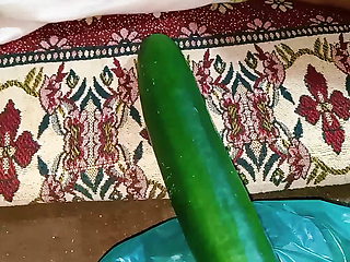 Aunty drains the water from the cucumber while relishing the cucumber to the fullest.